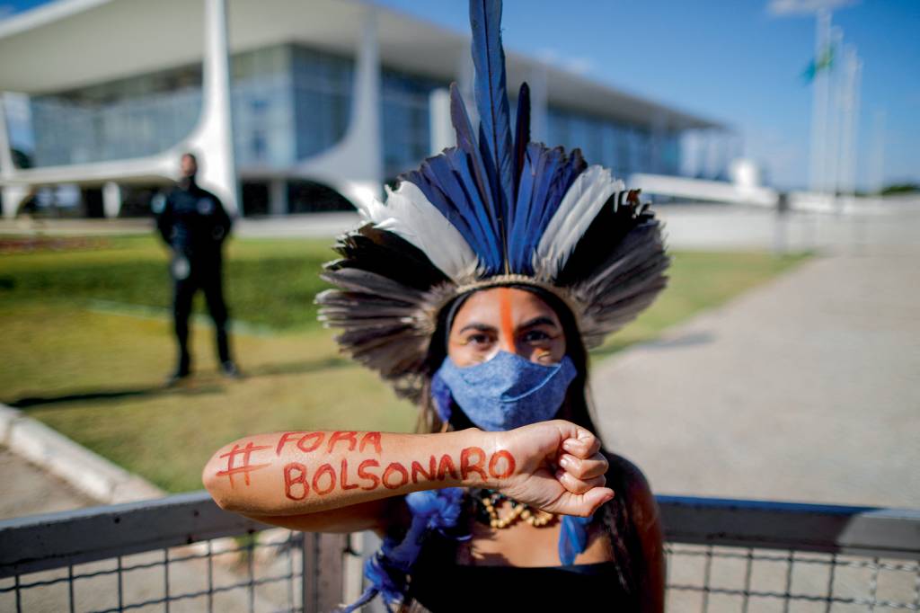 Indígena protestando contra o atual governo de Jair Bolsonaro FLECHADAS - Manifestação no Congresso: acusação de tirar direitos indígenas -
