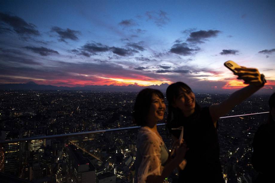 Mulheres posam para foto com o Monte Fuji ao fundo durante as Olimpíadas de Tóquio 2020 -