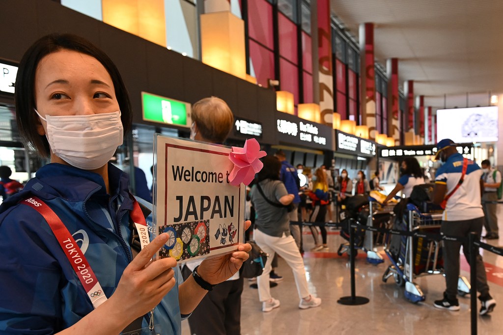 A volunteer staff welcomes the Olympic delegation at Narita International Airport in Narita, Chiba prefecture on July 20, 2021 to take part of the upcoming Tokyo 2020 Olympic Games. (Photo by Kazuhiro NOGI / AFP)