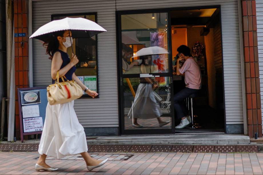 Pedestre passa em frente a restaurante em Shinagawa, Tóquio -