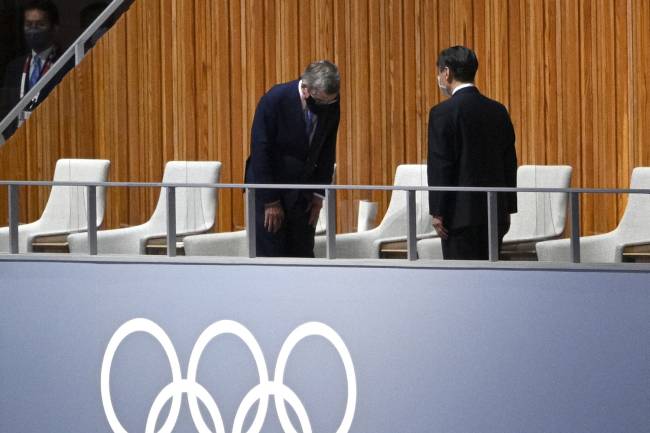 President of the International Olympic Committee (IOC) Thomas Bach (L) salutes Japan's Emperor Naruhito (R) as they attend the opening ceremony of the Tokyo 2020 Olympic Games, at the Olympic Stadium, in Tokyo, on July 23, 2021. (Photo by Martin BUREAU / AFP)