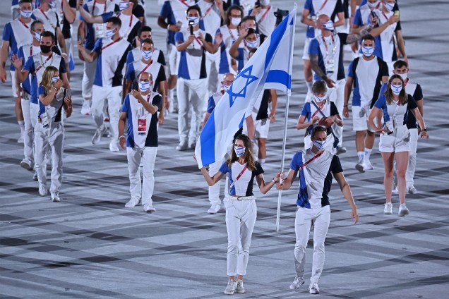 Hanna Minenko e Yakov Toumarkin carregam a bandeira de Israel e lideram a delegação na cerimônia de abertura dos Jogos Olímpicos de Tóquio, no Estádio Olímpico -