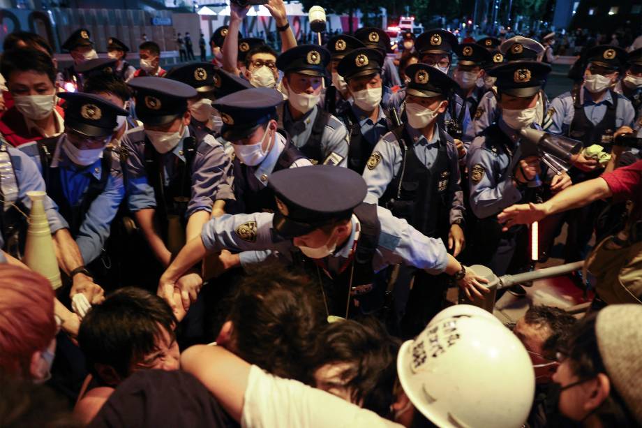 Policiais bloqueiam manifestantes que protestam contra os Jogos Olímpicos 2020 em frente ao Estádio Olímpico, em Tóquio -