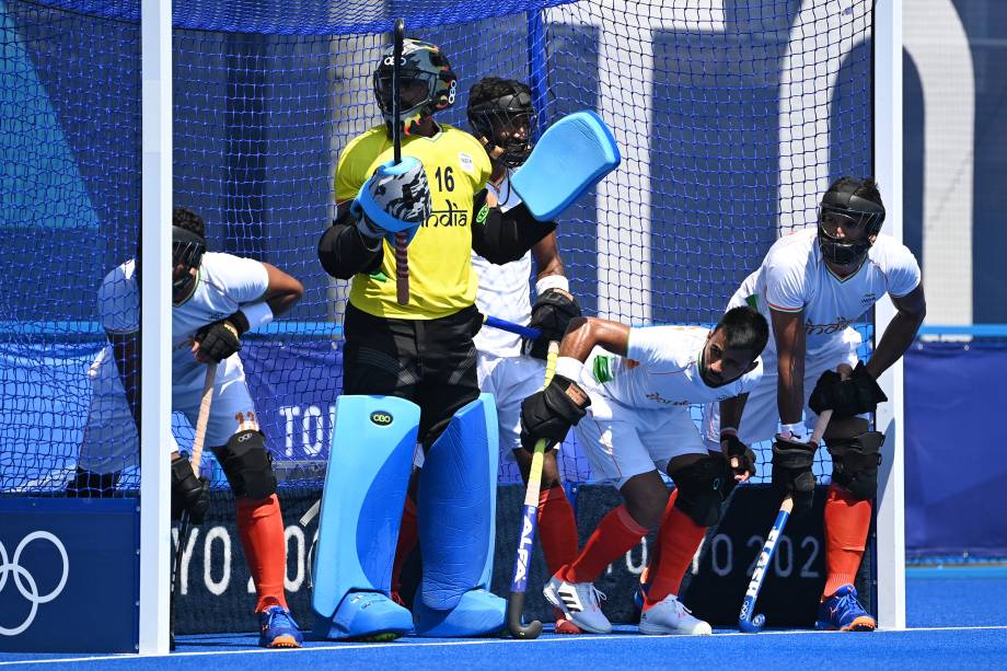 O goleiro Sreejesh Parattu Raveendran, da Índia, e seus companheiros de equipe defendem uma cobrança em partida contra a Nova Zelândia -