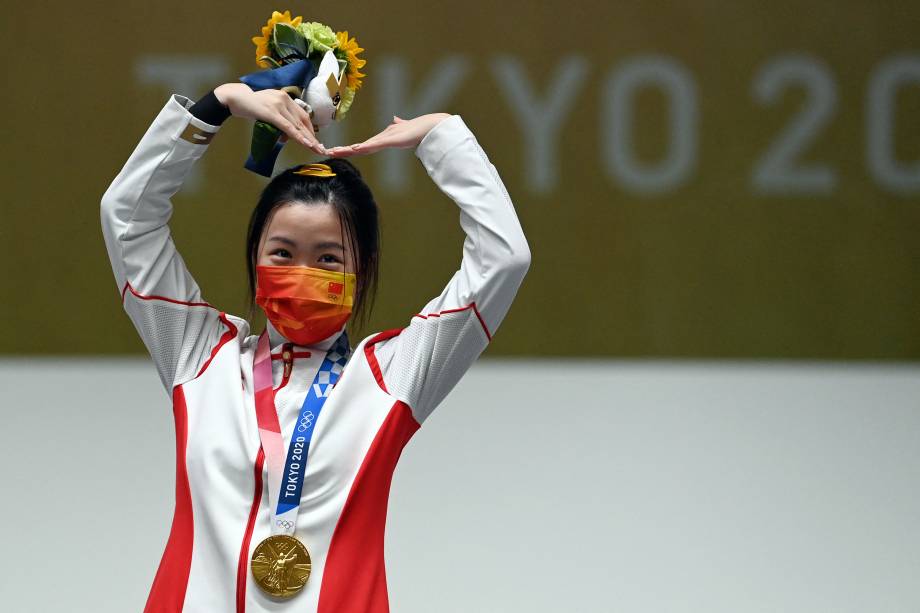 A chinesa Yang Qian, vencedora da primeira medalha de ouro, comemora no pódio após vencer a final do rifle de ar comprimido de 10m -