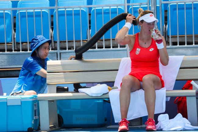 A tenista da Sérvia, Nina Stojanovic, se refresca com ar-condicionado durante a partida de tênis -