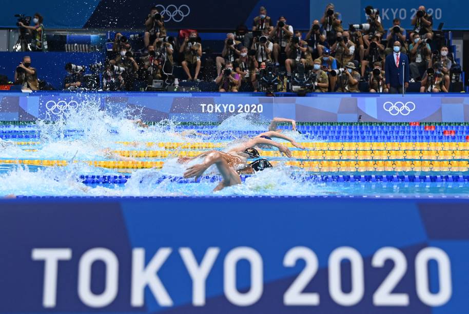 Com fotógrafos ao fundo, competidores nadam durante a prova medley individual de 400m -