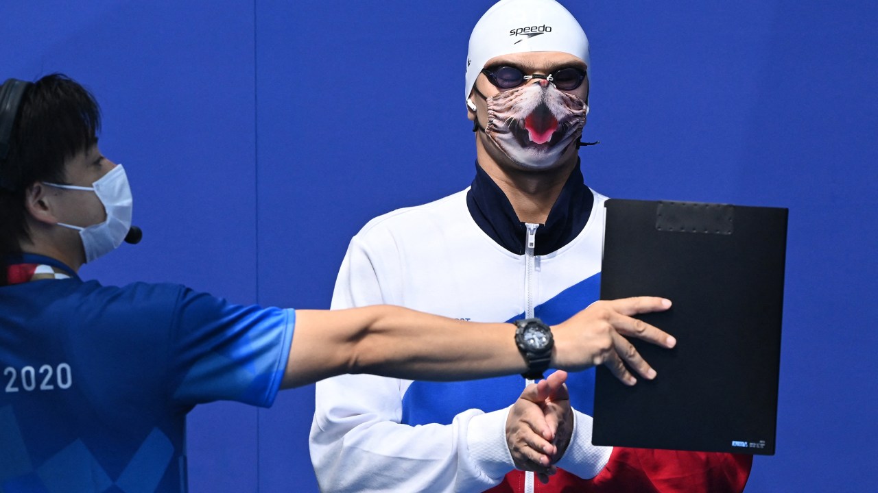 O russo Evgeny Rylov com sua máscara de felino enquanto espera pela cerimônia no pódio após a final da prova de 100m costas na natação -