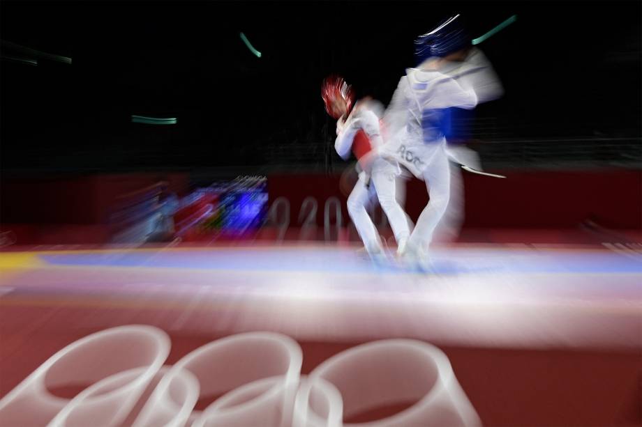 O russo Vladislav Larin (azul) e Pita Taufatofua, de Tonga, lutam em eliminatória do taekwondo -