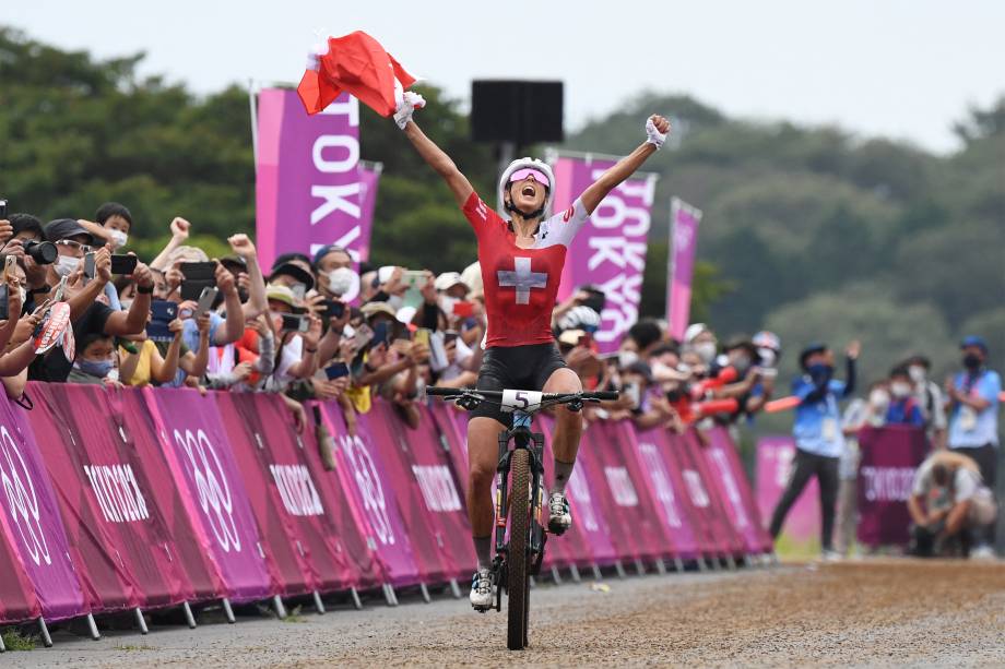 A suíça Jolanda Neff comemora ao se aproximar da linha de chegada e ganhar a medalha de ouro na corrida de cross-country -