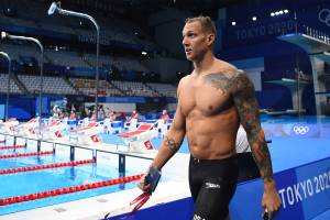 USA's Caeleb Dressel (L) walks past the pool after competing in a heat for the men's 100m freestyle swimming event during the Tokyo 2020 Olympic Games at the Tokyo Aquatics Centre in Tokyo on July 27, 2021. (Photo by Jonathan NACKSTRAND / AFP)