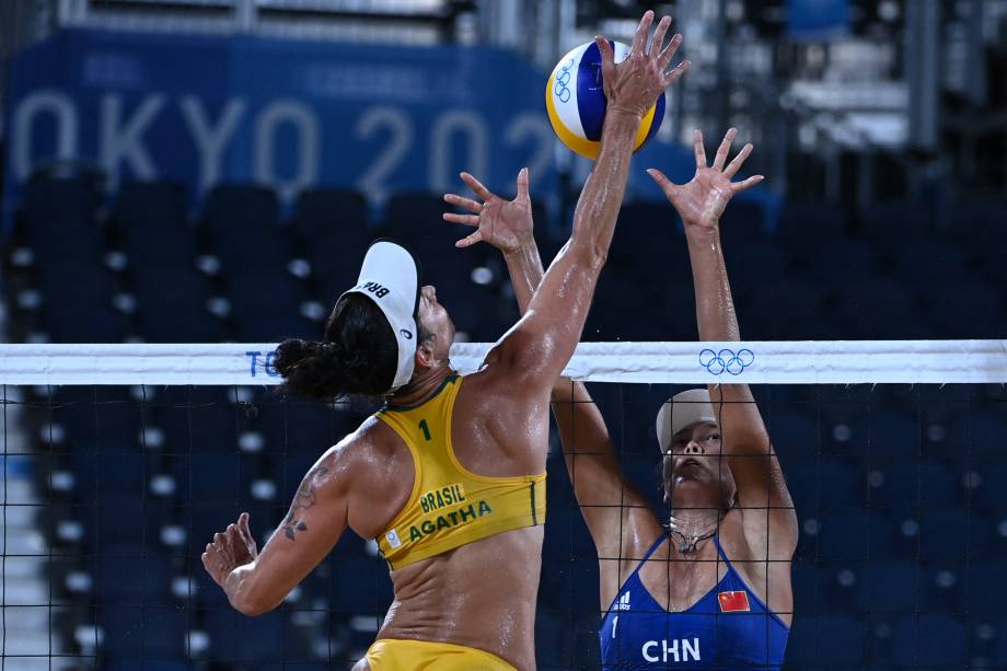 A chinesa Wang Fan tenta bloquear a brasileira Agatha Bednarczuk durante partida entre Brasil e China pelo vôlei de praia -