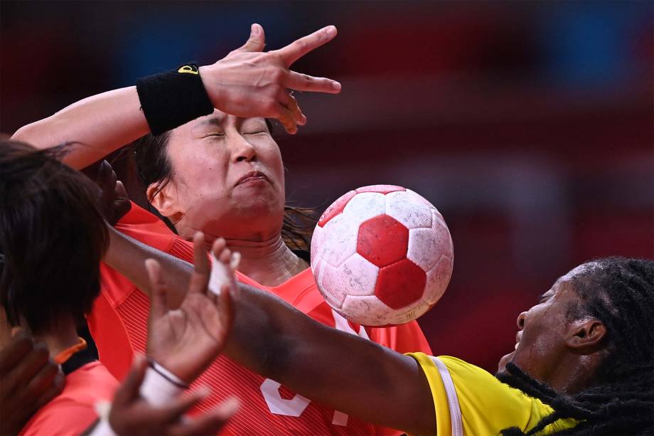 Jogadoras de Japão e Angola durante disputa pela bola em partida no handebol -