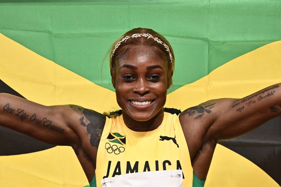 A atleta Elaine Thompson-Herah posando com a bandeira jamaicana -