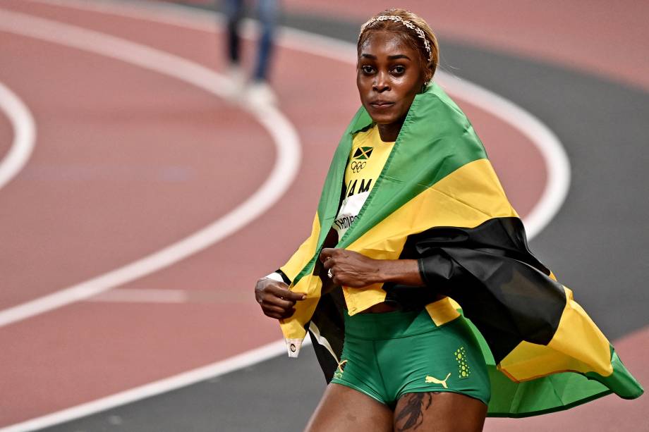 A atleta Elaine Thompson-Herah comemorando com a bandeira da Jamaica -