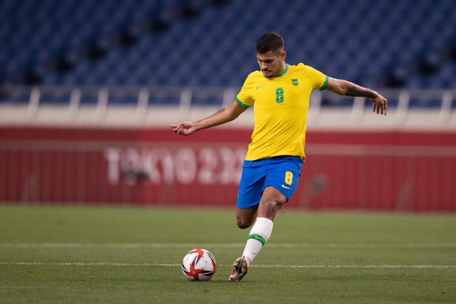 Bruno Guimarães durante lançamento de bola na partida -