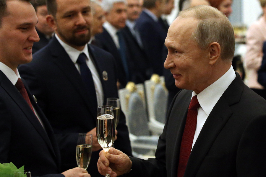 Russian President Vladimir Putin (R) toasts with Doctor of physics and mathematics Sergei Makarov (L)