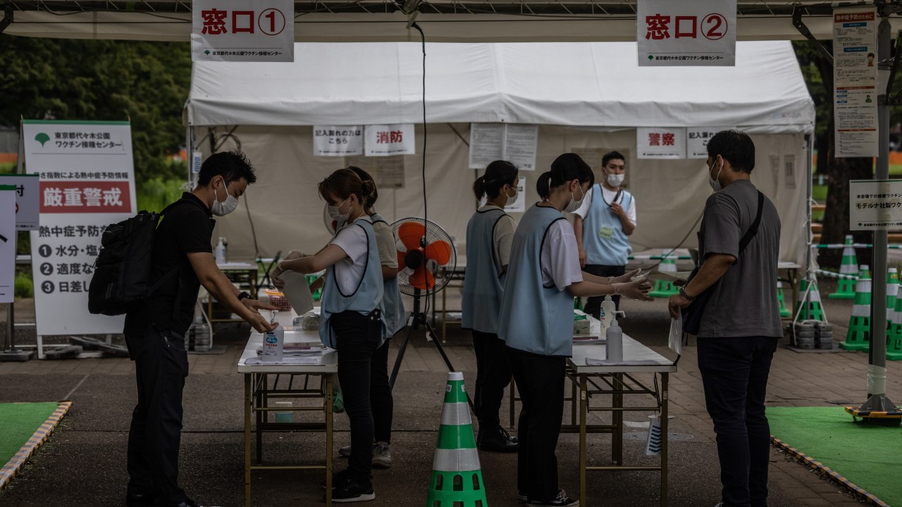 TOKYO, JAPAN - JULY 15: People arrive for inoculation against COVID-19 in an area of Yoyogi Park that was due to be a Tokyo Olympics fan park but has now been turned into a mass Covid-19 vaccination site, on July 15, 2021 in Tokyo, Japan. As Japan continues to grapple with the coronavirus pandemic, authorities have closed all fan parks in an effort to reduce the spread of the virus. (Photo by Carl Court/Getty Images)