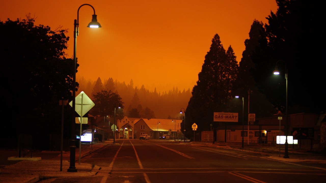 O céu fica laranja com a névoa da fumaça do incêndio Dixie em Greenvillein Quincy, Califórnia