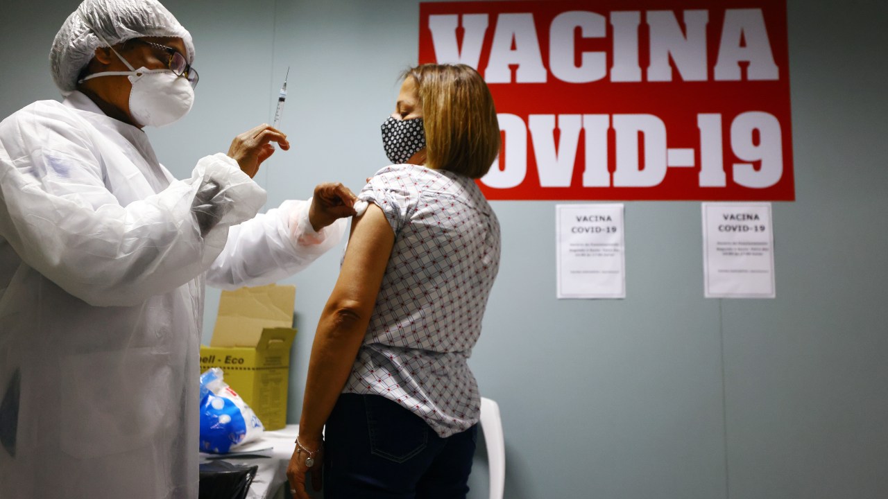 SAO PAULO, BRAZIL - MAY 20: A health worker applies a swab after administering a dose of the COVID-19 vaccine to a person at a vaccination post inside the Republica subway station on May 20, 2021 in Sao Paulo, Brazil. Vaccinations for eligible people are available in a number of public transportation stations in the city. Health experts are warning that Brazil should brace for a new surge of COVID-19 amid a slow vaccine rollout and relaxed restrictions. The state of Sao Paulo has registered over 3 million cases of COVID-19 and more than 100,000 deaths. Over 440,000 people have been killed in Brazil by COVID-19, second only to the U.S. (Photo by Mario Tama/Getty Images)