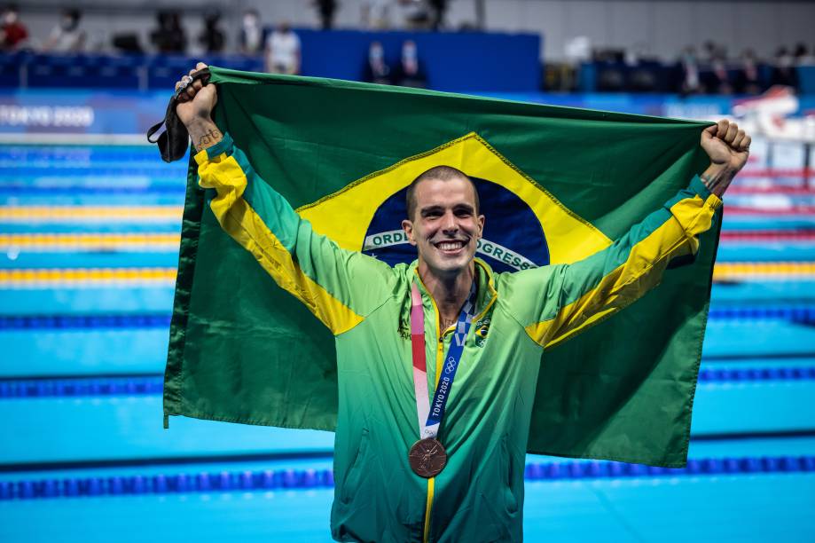 Fratus posando com a medalha de bronze e a bandeira do Brasil -