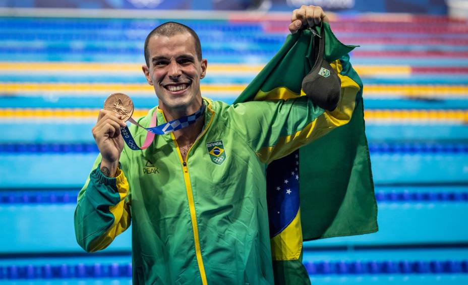 Fratus posando com a medalha de bronze e a bandeira do Brasil -