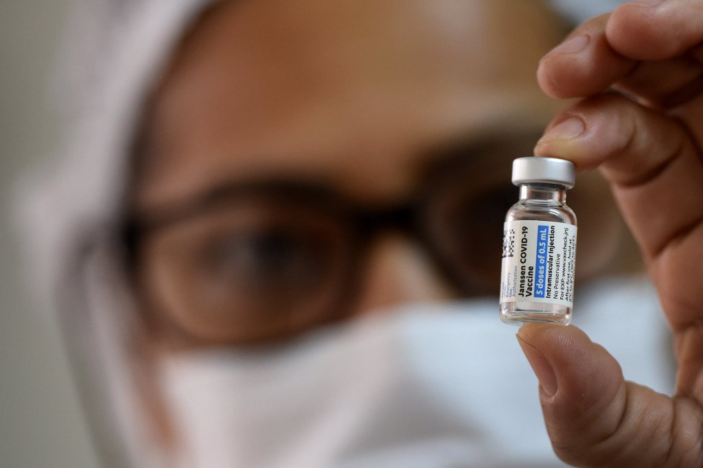 Agente de saúde observa frasco com dose da vacina Janssen, em Campinas