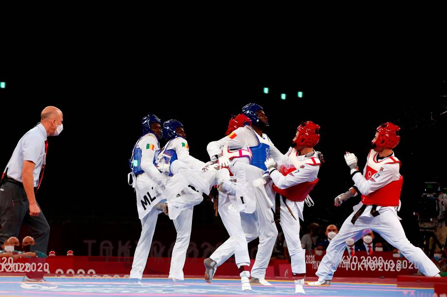 Seydou Fofana (azul), de Mali, e Ulugbek Rashitov (vermelho), do Uzbequistão, em prova do taekwondo masculino -