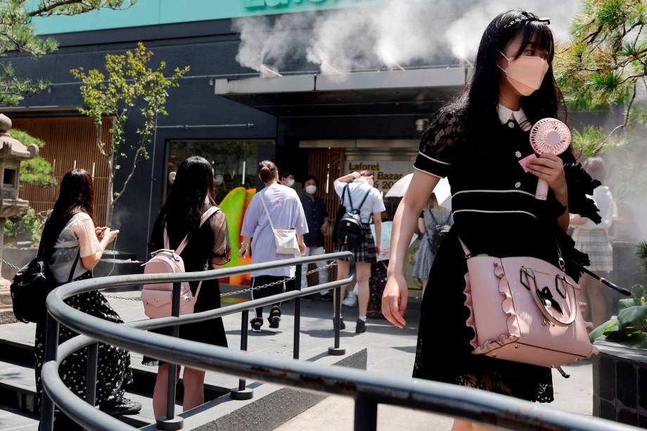 Mulher carrega ventilador portátil devido ao calor em Harajuku, Tóquio -