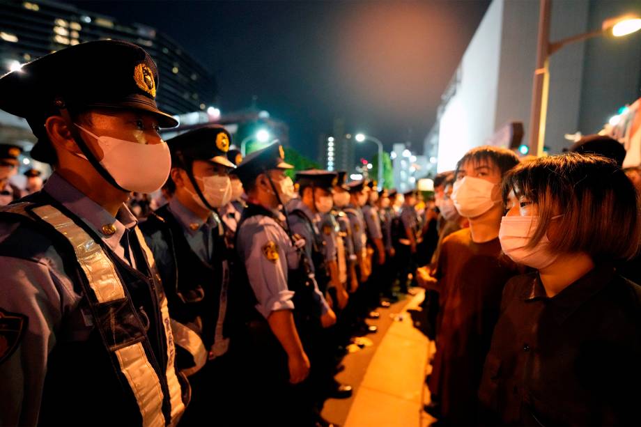 Policiais bloqueiam manifestantes que protestam contra os Jogos Olímpicos 2020 em frente ao Estádio Olímpico, em Tóquio -