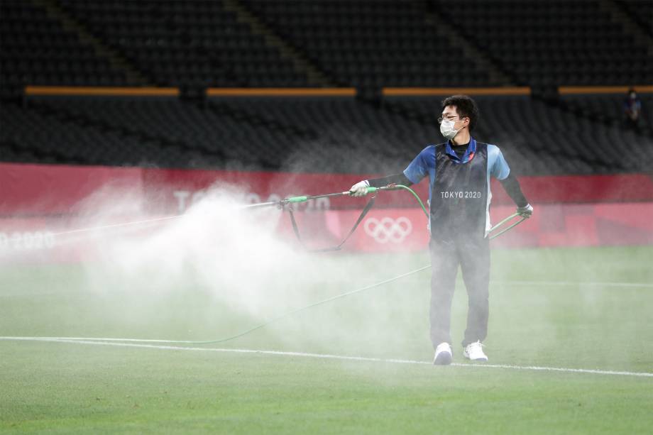 Voluntário desinfeta o Estádio Sapporo Dome antes de partida de futebol entre Argentina e Austrália -