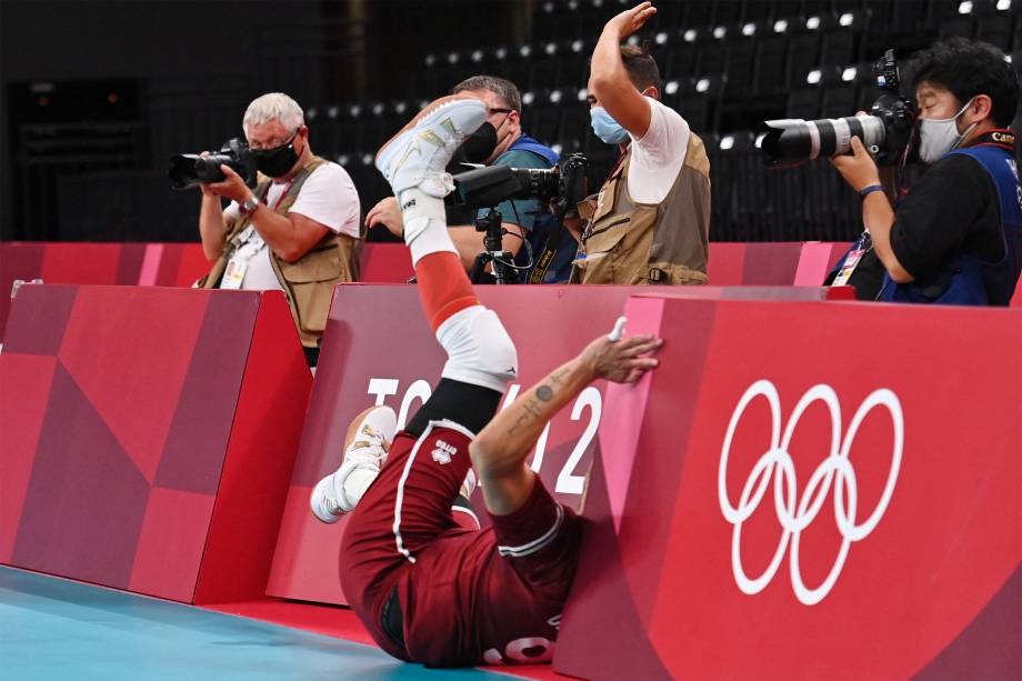 Jose Carrasco Angulo, da Venezuela, cai sobre as placas de proteção durante partida contra a Polônia pelo vôlei -