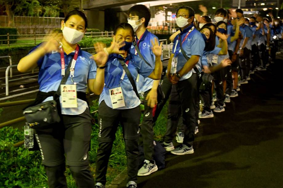 Voluntários japoneses em frente ao Tokyo Aquatics Centre -