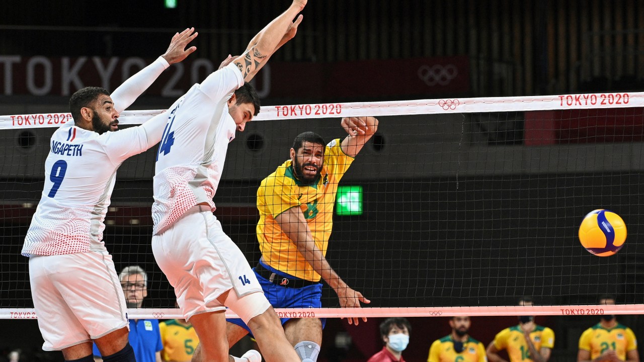 Brazil's Wallace de Souza (C) hits the ball in the men's preliminary round pool B volleyball match between Brazil and France during the Tokyo 2020 Olympic Games at Ariake Arena in Tokyo on August 1, 2021. (Photo by Anne-Christine POUJOULAT / AFP)