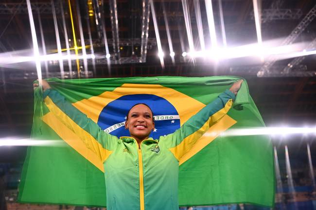 Rebeca Andrade posa com a bandeira brasileira após o ouro