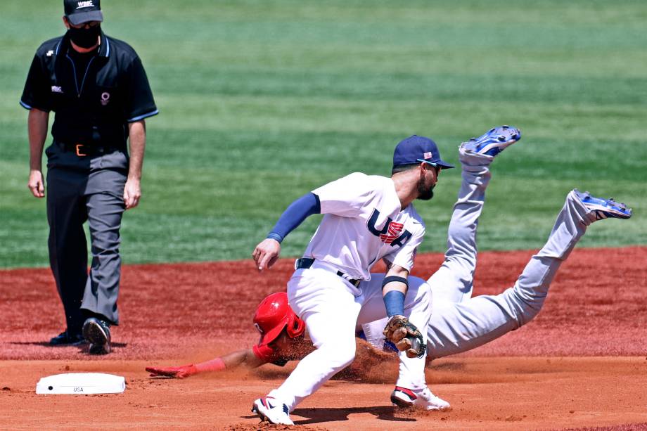 Erick Mejia, da República Dominicana, mergulha na segunda base enquanto o americano Eduardo Alvarez pega bola em partida de beisebol -