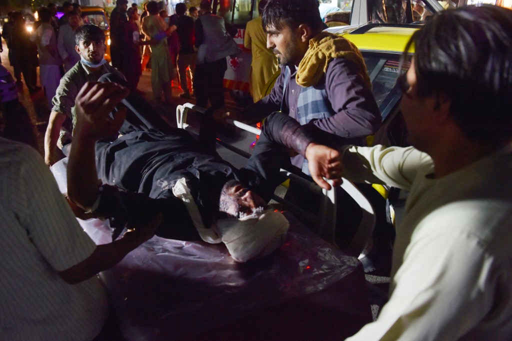 Equipe médica socorre homem machucado após explosão nos arredores do aeroporto de Cabul, no Afeganistão