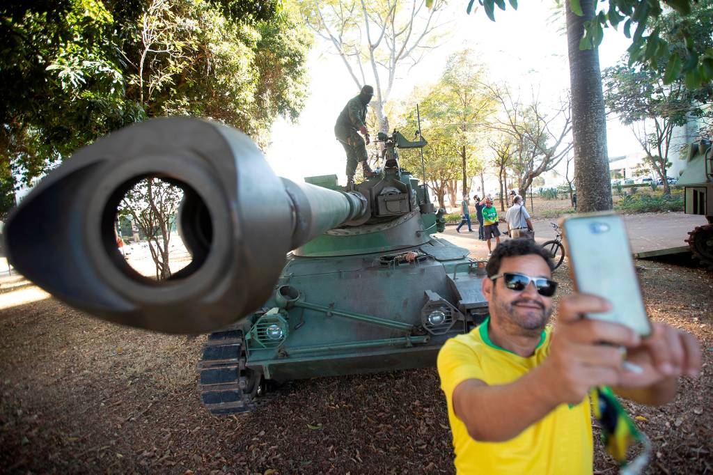 BRA121. BRASÍLIA (BRASIL), 10/08/2021. - Simpatizantes del presidente de Brasil, Jair Bolsonaro, se toman fotografías junto a los tanques estacionados en la Esplanada do Ministerios, este martes en la ciudad de Brasilia. El presidente de Brasil, Jair Bolsonaro, recibió este martes un inusual desfile militar en Brasilia, un despliegue que fue visto por la oposición como un intento de líder de la ultraderecha brasileña por intimidar al Congreso durante una votación clave para el Gobierno. EFE/ Joédson Alves