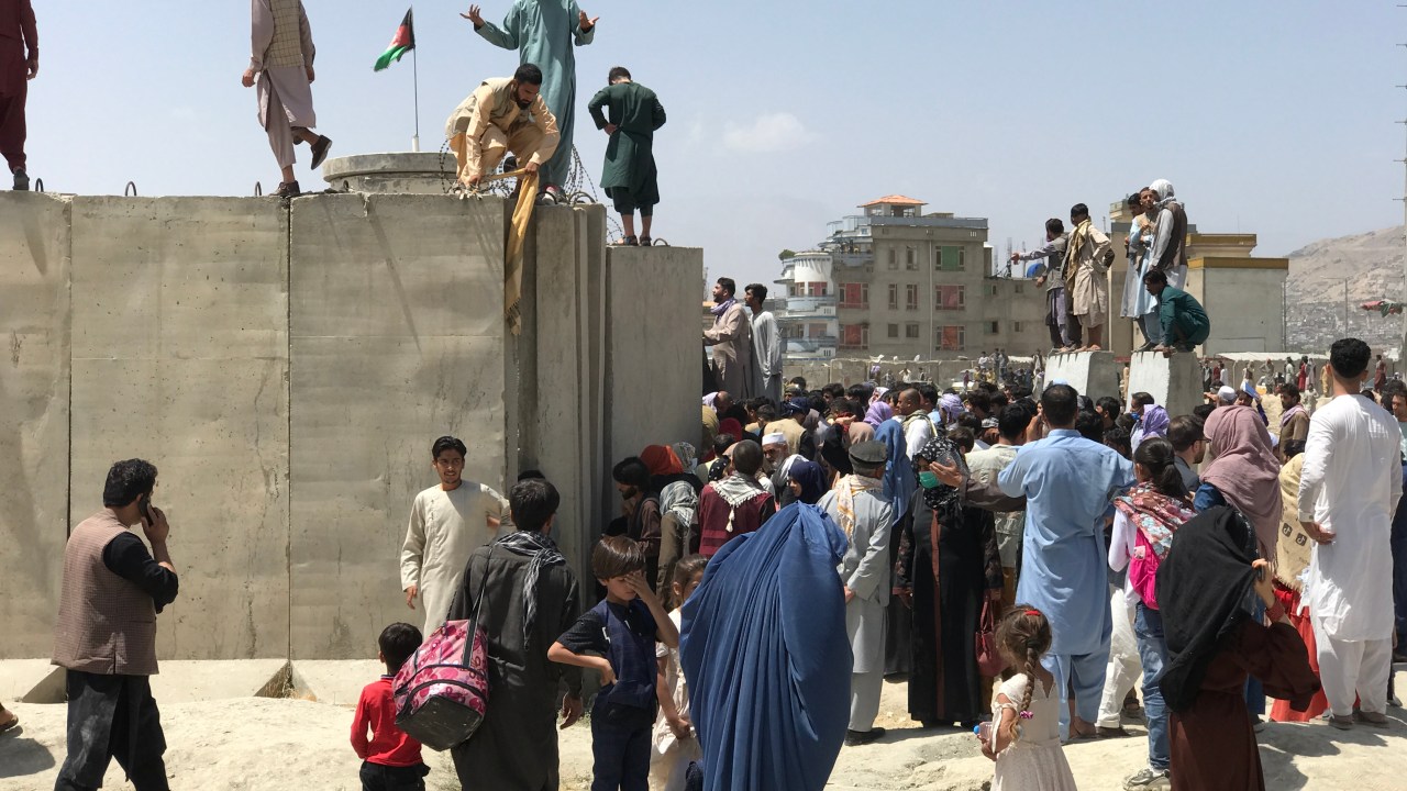 Pessoas tentam entrar no aeroporto internacional Hamid Karzai para fugir do Afeganistão. 16/08/2021