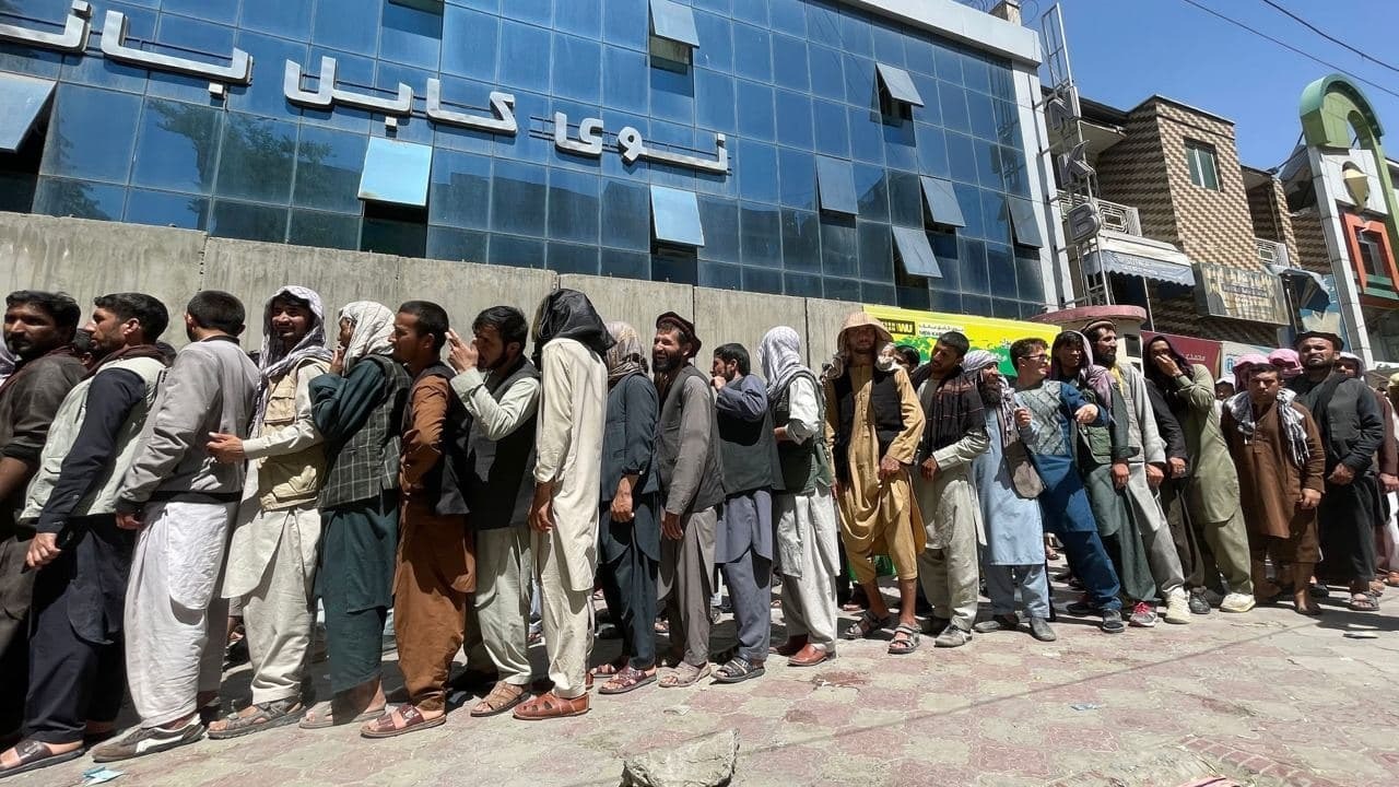 Afegãos aguardam abertura de banco no centro de Cabul nesta quarta-feira (25)