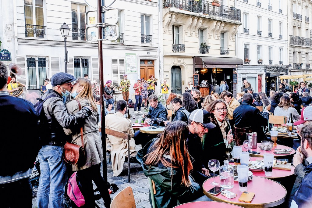 Parisienses tomam drinques em um bar no distrito de Montmartre