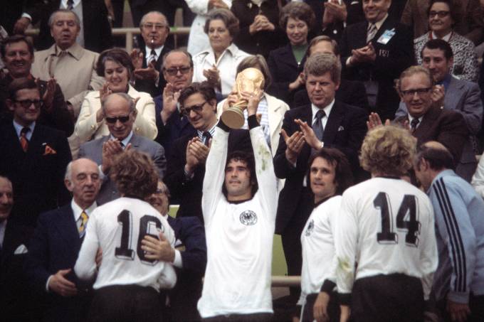 1974 FIFA World Cup in Germany Final in Munich: Germany 2 – 1 Netherlands – Gerd Mueller holding up the trophy at the award ceremony| towards the right: Wolfgang Overath, Hoeness, coach Helmut Schoen – 07.07.1974 Identical with image no xy
