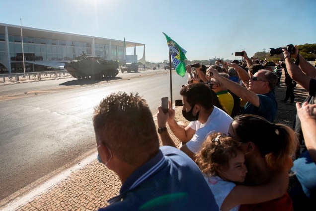 Apoiadores do presidente Jair Bolsonaro observam a chegada de um comboio militar na Esplanada do Ministerios -