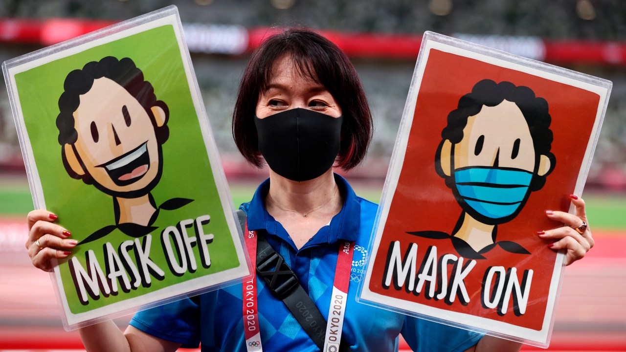 Tokyo (Japan), 06/08/2020.- A staff member holds placards 'Mask Off' and 'Mask On' before the medal ceremonies during the Athletics events of the Tokyo 2020 Olympic Games at the Olympic Stadium in Tokyo, Japan, 06 August 2021. (Japón, Tokio) EFE/EPA/WU HONG