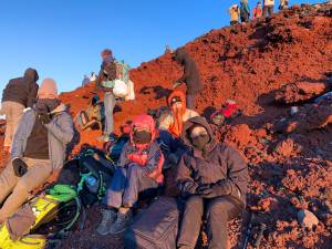 Tadashi, Erica, Max e Nina no topo do Monte Fuji, acompanhando o amanhecer -