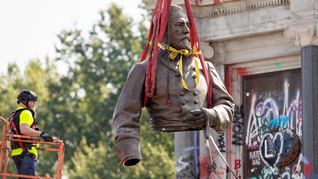 The top half of the statue of former Confederate General Robert E. Lee is lifted away after being cut off and removed from Monument Avenue in Richmond, Virginia on September 8, 2021. - A statue of a Confederate general that became the focus of US protests for racial justice was removed on September 8, 2021 in Richmond, the Virginia city that served as capital of the pro-slavery South during the Civil War. The statue of General Robert E. Lee, who commanded the Army of Northern Virginia during the bloody 1861-65 conflict, was lifted off its 40-foot (12-meter) granite pedestal by a crane to be carted away on a flatbed truck as a crowd of hundreds cheered under tight security. (Photo by Ryan M. Kelly / AFP)