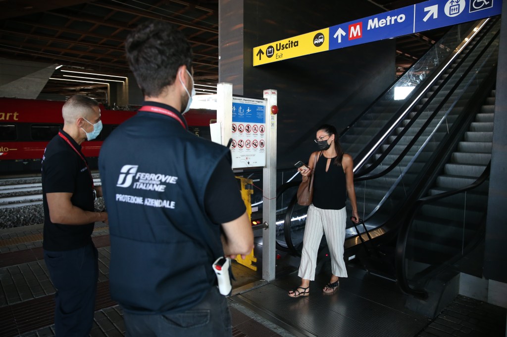 Passageira mostra passe sanitário a funcionários de estação de trem em Roma, Itália. 01/09/2021