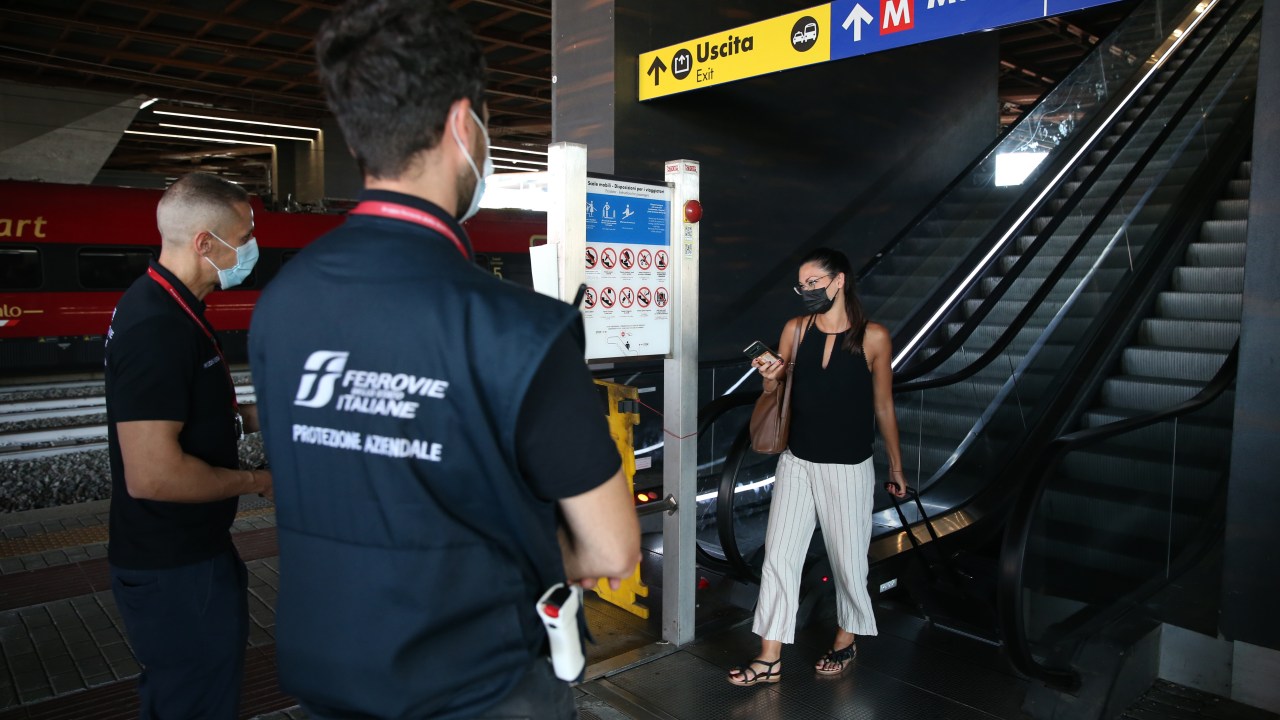 Passageira mostra passe sanitário a funcionários de estação de trem em Roma, Itália. 01/09/2021