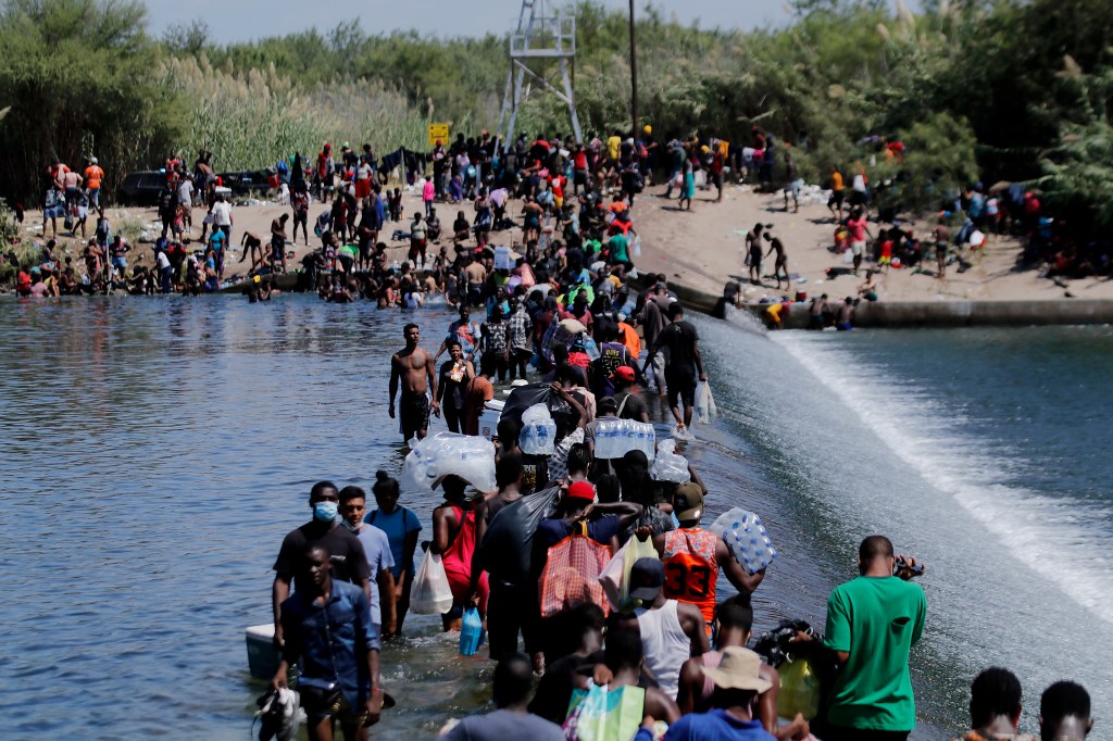 Imigrantes cruzam a fronteira do México com os Estados Unidos neste sábado (18)