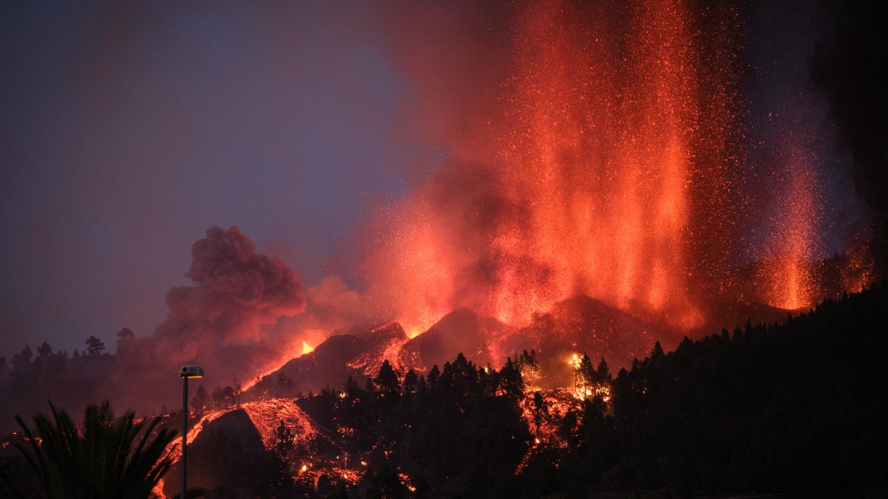 EL PASO, SPAIN - SEPTEMBER 19: Mount Cumbre Vieja erupts in El Paso, spewing out columns of smoke, ash and lava as seen from Los Llanos de Aridane on the Canary island of La Palma on September 19, 2021. - The Cumbre Vieja volcano erupted on Spain's Canary Islands today spewing out lava, ash and a huge column of smoke after days of increased seismic activity, sparking evacuations of people living nearby, authorities said. Cumbre Vieja straddles a ridge in the south of La Palma island and has erupted twice in the 20th century, first in 1949 then again in 1971. (Photo by Andres Gutierrez/Anadolu Agency via Getty Images)